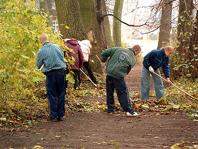 Młodzież ze Szkoły Podstawowej Nr 7 porządkująca  aleje na cmentarzu 