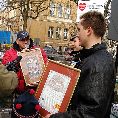 Pan Grzegorz odbiera certyfikat i podziękowanie za udział w internetowej licytacji nazwy mostu.